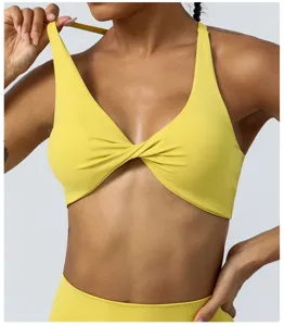 Close-up detail of women yellow twist front sports bra yoga activewear fitness gym top.