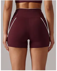 Vue détaillée de short de yoga bordeaux à taille haute avec élégants liserés blancs.