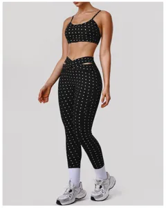 Zwarte yogaset met stipjes, voorzien van een ondersteunende sport-bh en hoge crossover legging.