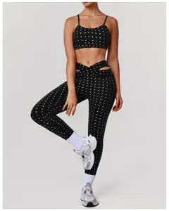 Gedetailleerde zwart-witte polkadot sportbeha en kruistaille hoge taille yoga leggings set.