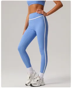 Detail van sportieve yogabroek met hoge taille, contrasterende witte bies en fijne pasvorm.