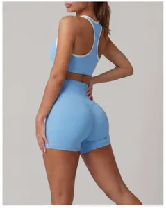 Dettaglio ravvicinato del top sportivo azzurro con bordo a contrasto e pantaloncini.
