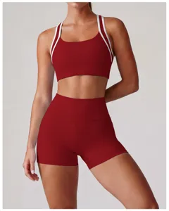 Dettaglio in primo piano di reggiseno sportivo bordeaux e pantaloncini a vita alta.