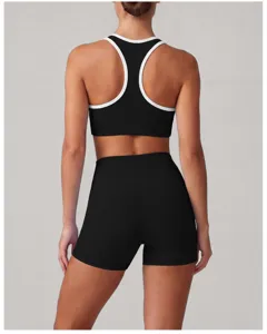 Dettaglio posteriore del set reggiseno sportivo nero e pantaloncini con bordo bianco.