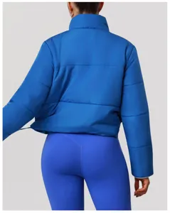 Vista posteriore dettagliata di giacca puffer blu da donna e leggings sportivi, vestibilità calda.