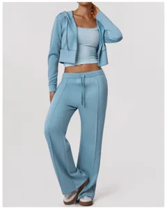 Ensemble de sport femme bleu clair avec sweat court debardeur et pantalon yoga fitness.