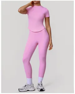 Vista dettagliata del top sportivo rosa e dei leggings da yoga a vita alta sulla modella.