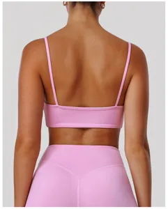 Détail de soutien-gorge de sport rose dos nu avec fines bretelles et leggings de fitness.