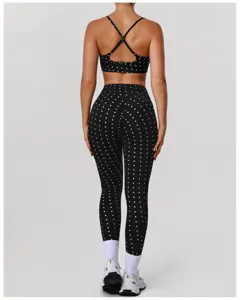 Zwarte yogaset met polkadots, kruisrug sportbeha en billenliftende fitnessbroek voor dames.