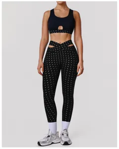 Gedetailleerd overzicht van zwarte yoga-set met stippen en hoge taille sportlegging.