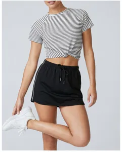 Women athletic tennis yoga skort with stripe tee and sneakers, casual activewear detail shot