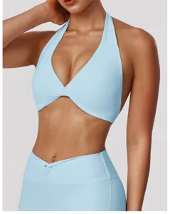 Detail view of light blue halter yoga bra and activewear top with crossover design features.