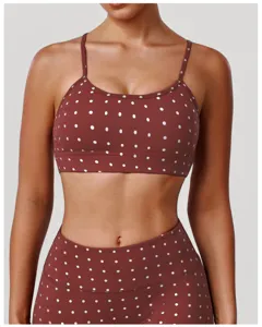 Vue détaillée d'un soutien-gorge de sport et legging marron à pois argentés, fines bretelles.