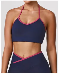 Vue détaillée du soutien-gorge de sport bleu foncé avec bordure rose et leggings.