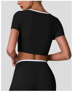 Detail van een zwarte crop top met witte contrasterende bies voor fitnesskleding.