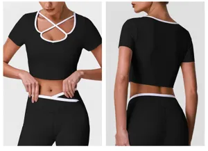 Close-up detail van zwarte yoga crop top met witte contrasterende biezen en bandjes.