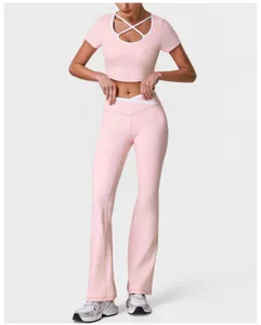 Roze crop top met kruislingse halslijn en bijpassende uitlopende yogabroek detail.