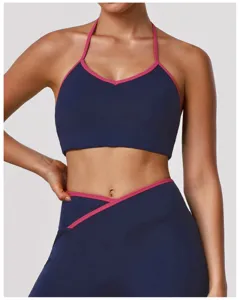 Gros plan d'un soutien-gorge de yoga dos-nu bleu foncé et leggings à bordure rose.