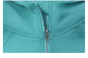 Detail view of turquoise zip hoodie collar and metal zipper, showing fine stitching quality.