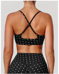 Vue arrière d'un soutien-gorge de sport noir à pois avec fines bretelles croisées et élasticité.