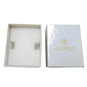 Detail of a high-end rectangular white watch box with foam insert and golden logo