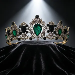 Close-up of vintage bridal crown with emerald green crystals and gold filigree.