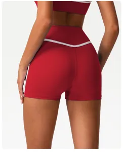 Close-up detail of high-waisted red yoga shorts with contrast white piping for active fitness.