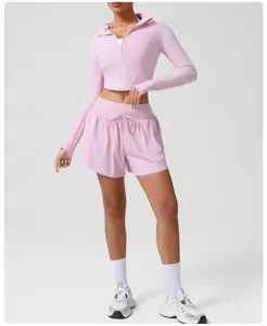 Pink activewear set with cropped zip-up jacket and high-waisted shorts for women fitness yoga gym.