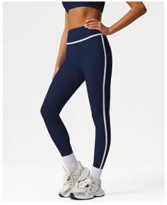 Detail view of high-waist athletic leggings in dark blue with stylish white piping accents.