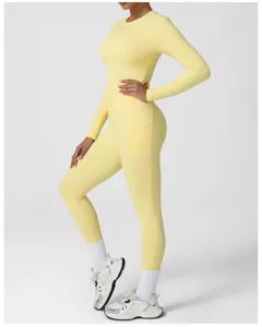 Detailed view of women's light yellow long-sleeve athletic top and matching pocket leggings.