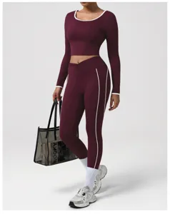 Completo da yoga crop top a manica lunga e leggings bordeaux con profili bianchi per donna sport.