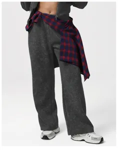 Close-up detail of dark grey acid wash sweatpants and plaid shirt tied around waist.