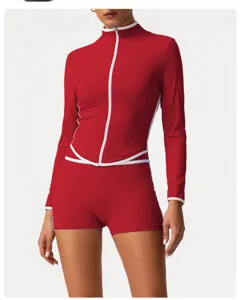Close-up detail of red activewear set featuring white piping, zip-up top and high-waist shorts.