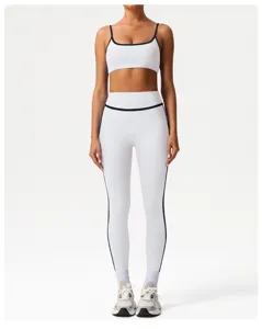 Detail shot of white athletic leggings and sports bra set with dark trim, high elastic fit.