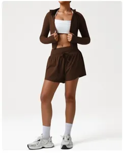 Detailed view of the brown athletic zip jacket, white sports bra and matching running shorts.