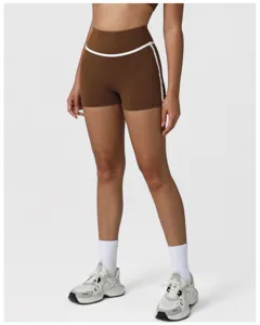 Detail view of women's brown high-waisted athletic yoga shorts with white contrast piping.