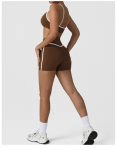Detail view of brown athletic sports bra and high-waisted yoga shorts with white trim.