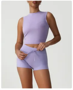 Vue détaillée du crop top de sport mauve clair et du short de fitness élégant.