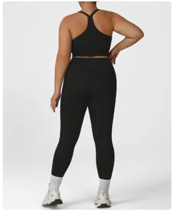 Vue détaillée de la brassière de sport noire et du legging taille haute portés par le mannequin.