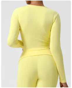 Vue arrière détaillée d'un crop top jaune à manches longues et de leggings assortis.