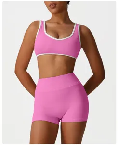 Ensemble de sport rose avec soutien-gorge et short taille haute à bordure blanche.