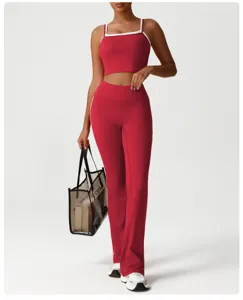 Vue détaillée de l'ensemble haut de fitness rouge et pantalon de yoga évasé en studio.
