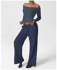 Detailed view of the dark blue off-the-shoulder long sleeve top and loose wide-leg pants.