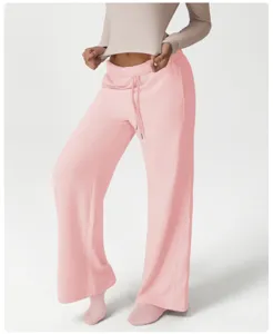 Close-up detail of casual loose wide-leg sweatpants in pink, highlighting the elastic drawstring waist.
