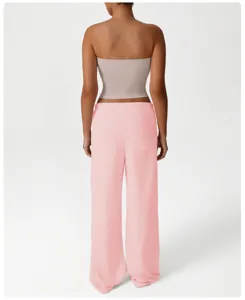 Vista posterior detallada de pantalones deportivos rosas y top bandeau para mujer.