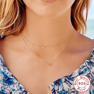 Close-up of a double layer sterling silver gold necklace featuring delicate pendants