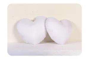 Vue de detail en gros plan d'inserts de coussin blanc en forme de coeur texture douce.