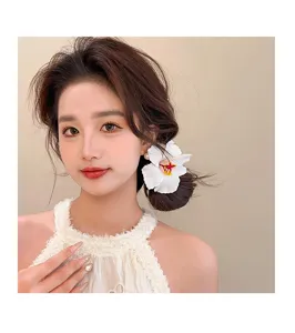 Gros plan d'une jolie pince à cheveux fleur d'hibiscus blanche de style vacances chic.