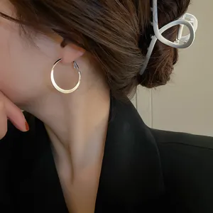 Minimalist large metal hoop earrings detail shot, elegant silver tone fashion jewelry for women.
