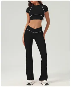 Completo sportivo da donna con crop top nero e pantaloni yoga svasati fitness set.